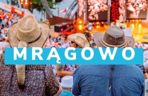 Widok na tłum ludzi na festiwalu w Mrągowie, z widocznymi osobami w kapeluszach, cieszącymi się atmosferą wydarzenia. Na tle sceny widać kolorowe światła i ekrany, co podkreśla wyjątkowy klimat imprezy.